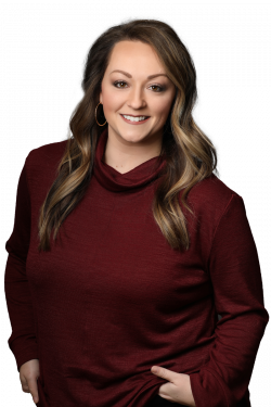 Smiling woman with long chestnut hair and dard red sweater